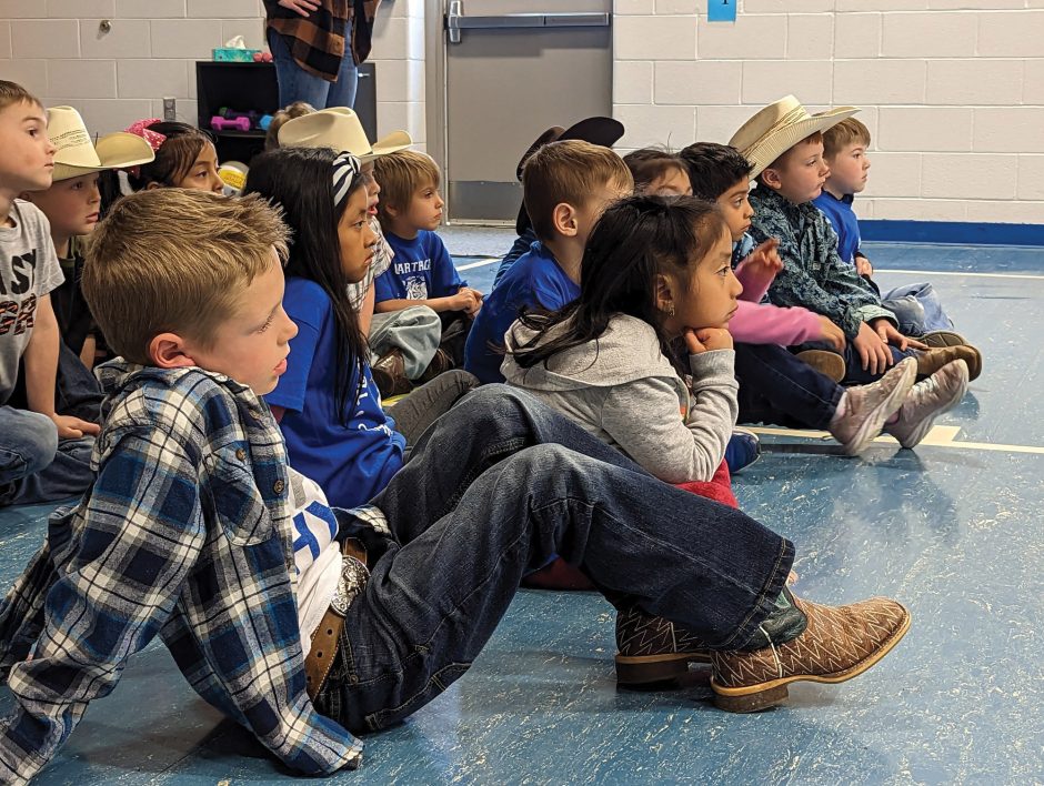 elementary school children listening to speaker