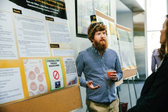 professor standing by presentation board