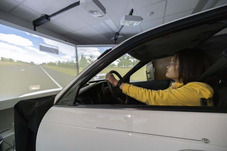 Picture of a car in a transportation simulation lab surrounded by 180 degrees of computer screens