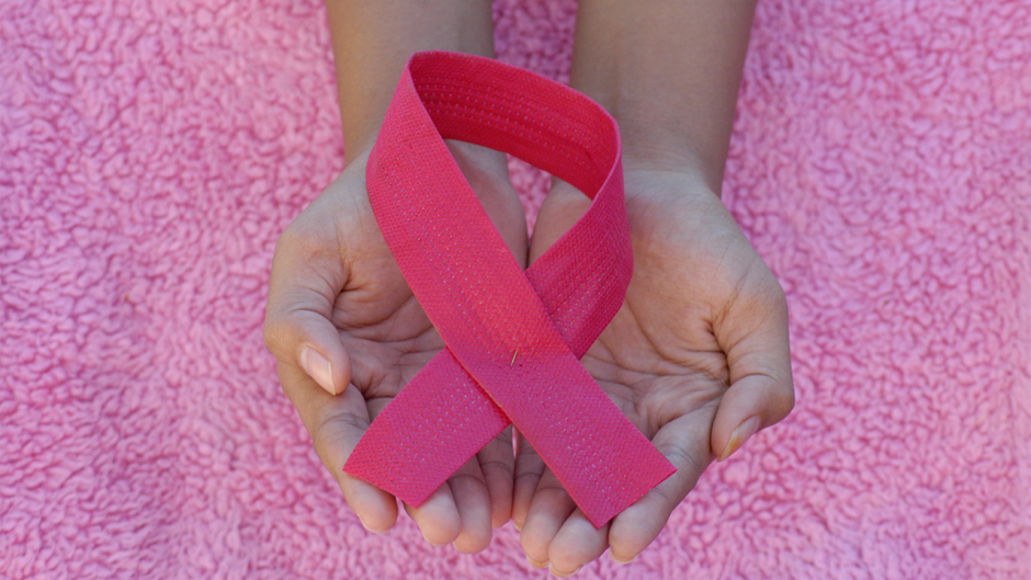 pink ribbon being held in hands