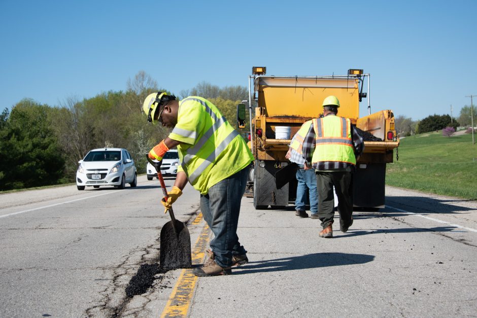 MoDOT workers fixing potholes on a two-lane road