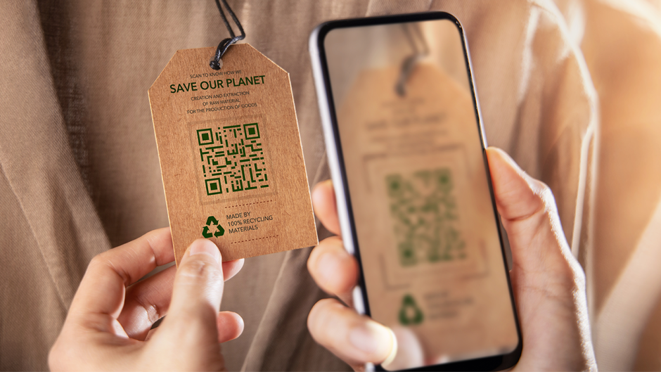 A person scanning a QR code about sustainability on a clothing tag.