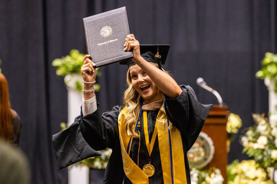 a graduate showing off her diploma