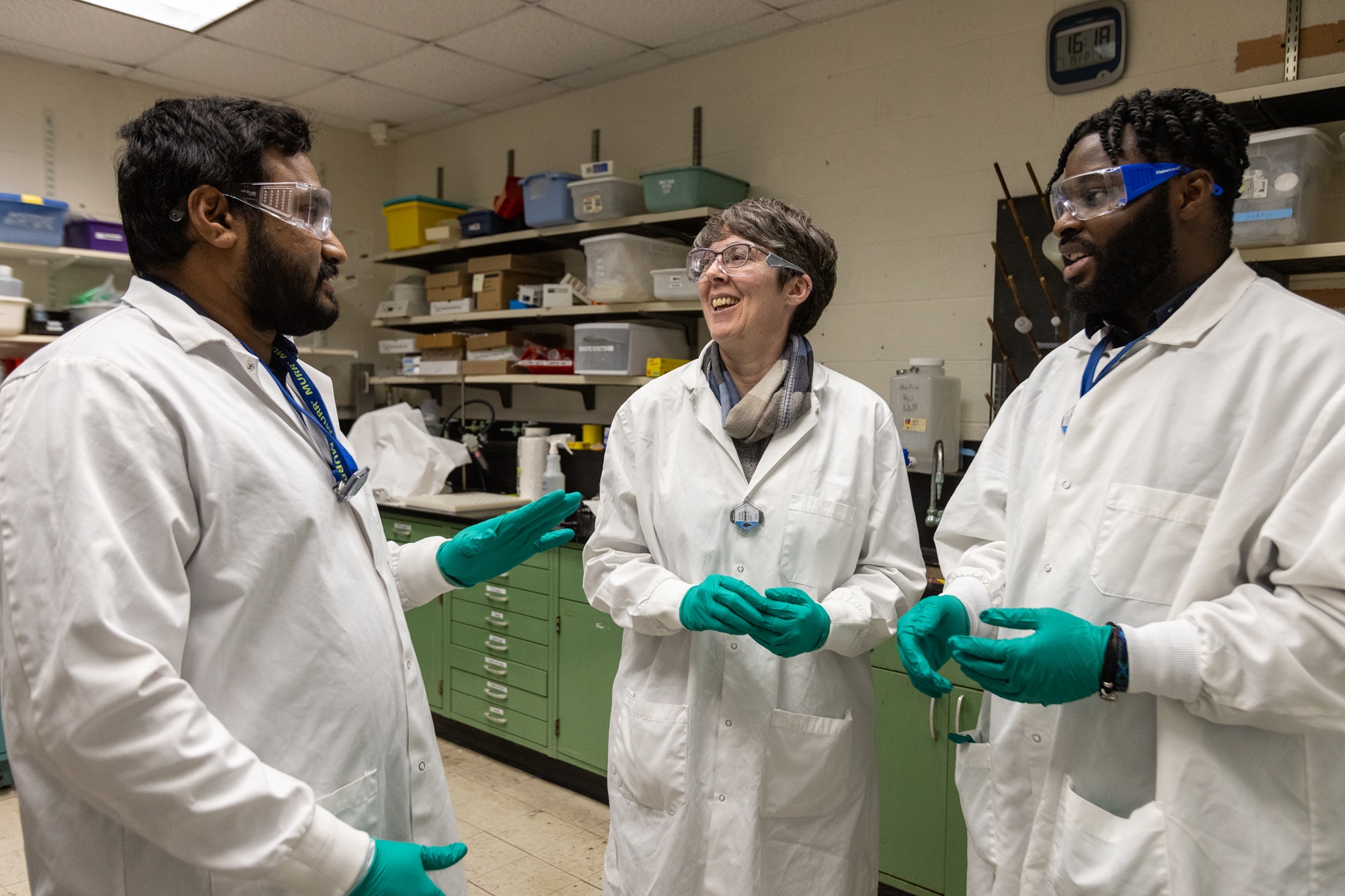 three researchers talking in a lab