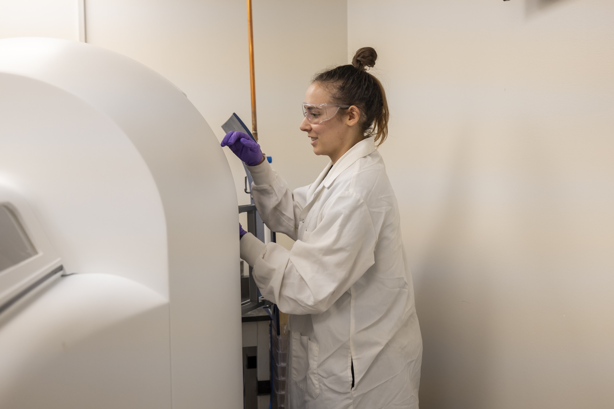 researcher loads a sample into a machine