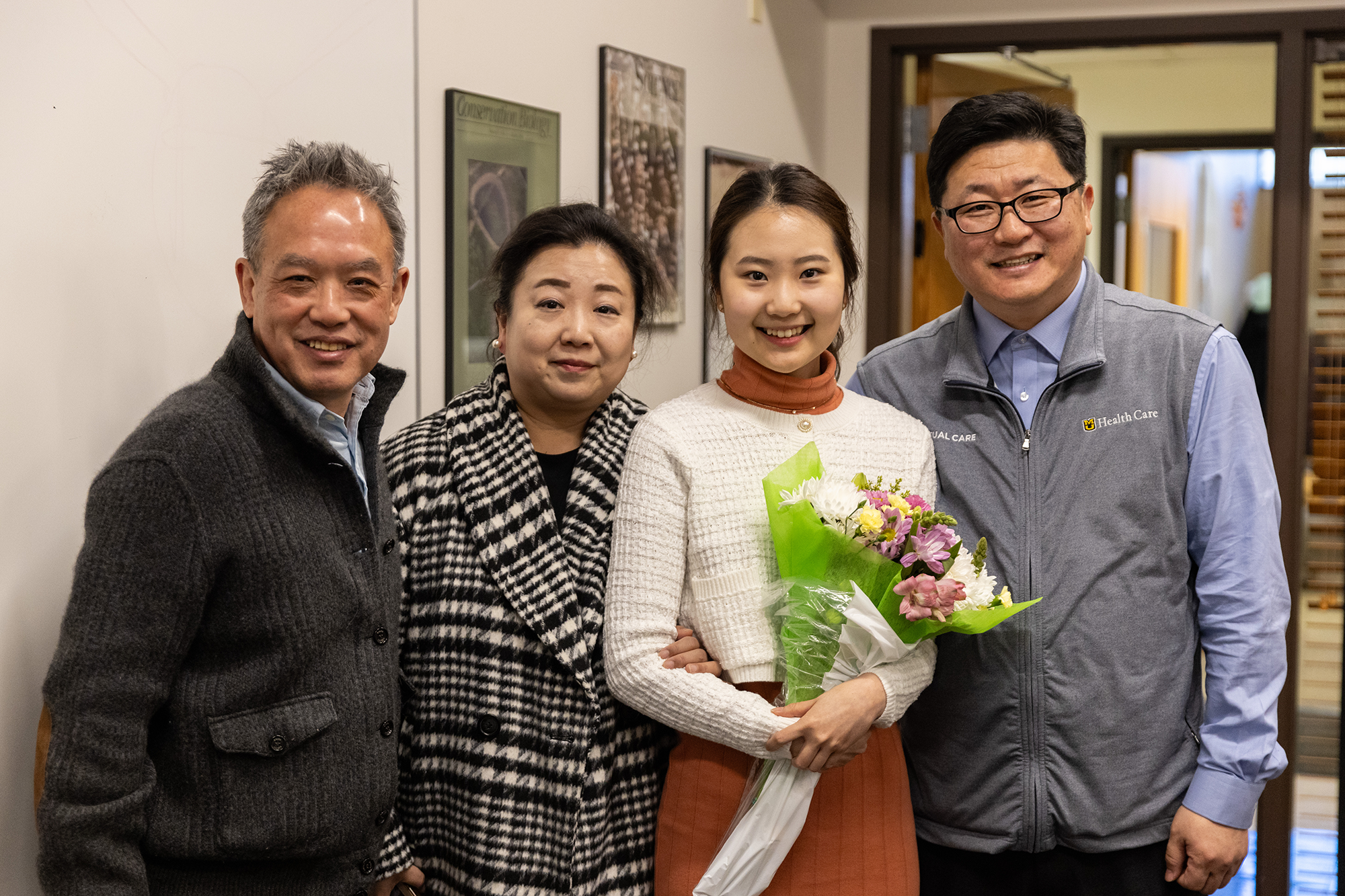 Jenny Park posing with her parents and mentor, Bing Zhang, a professor of biological sciences in the College of Arts and Science.