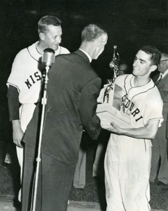 baseball player receiving trophy