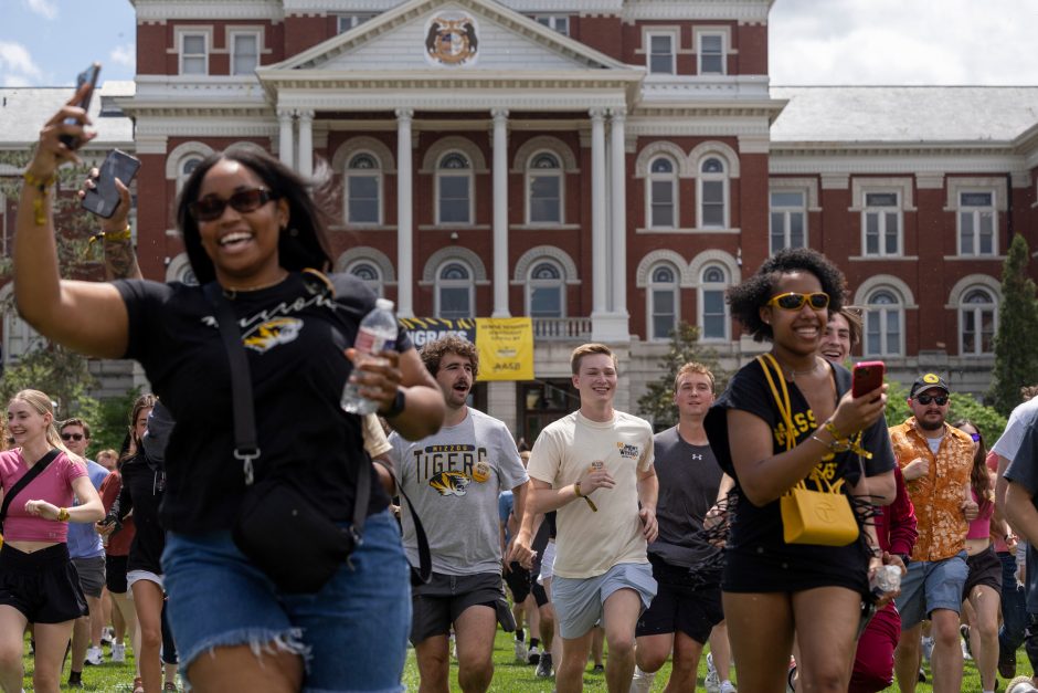 Students with phones run on Quad