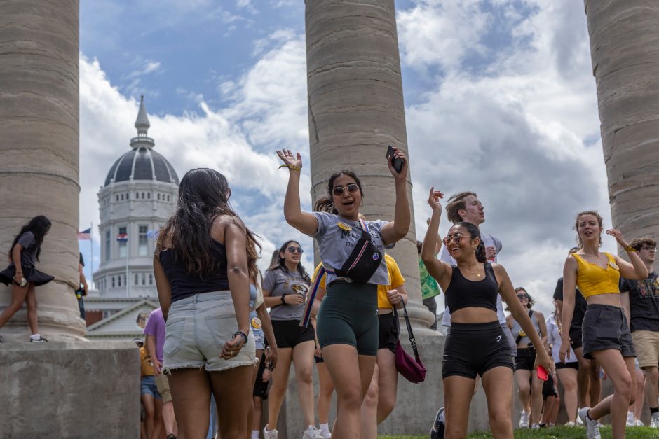 Students raise arms at base of Mizzou columns