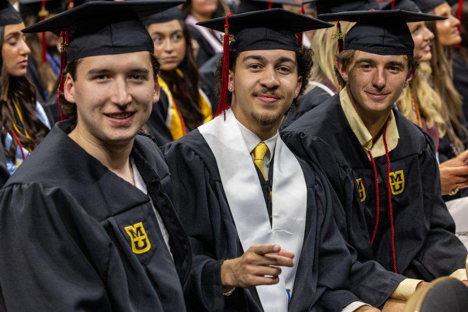 Graduates smile at camera