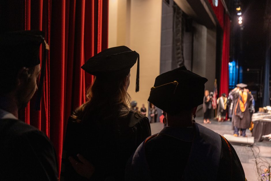 Graduates look from behind stage