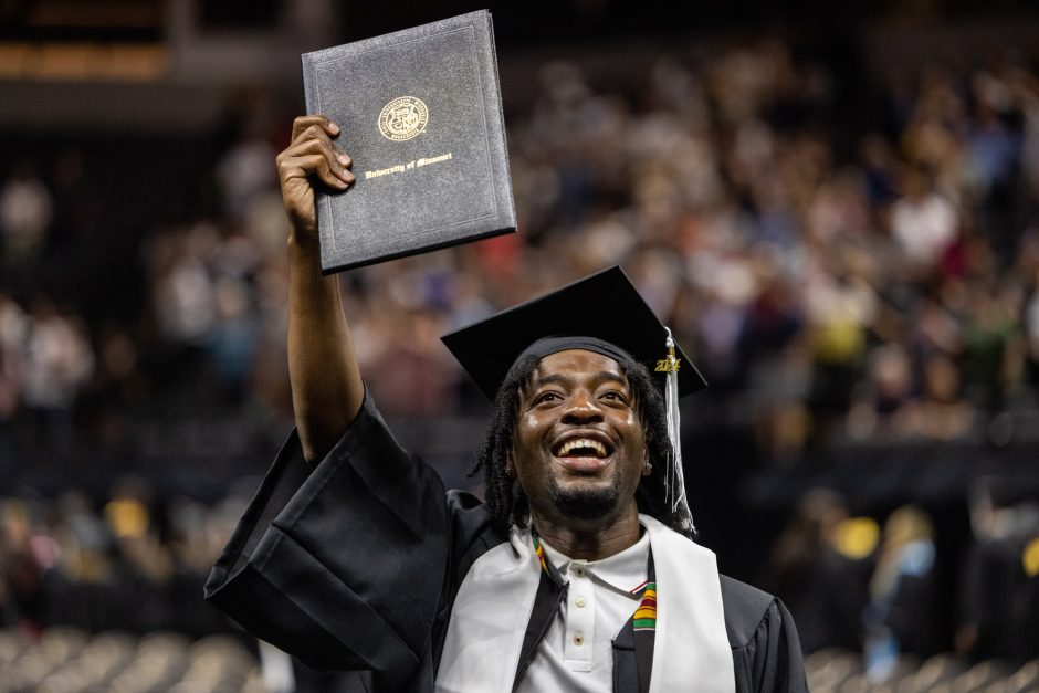 Graduate holds up degree