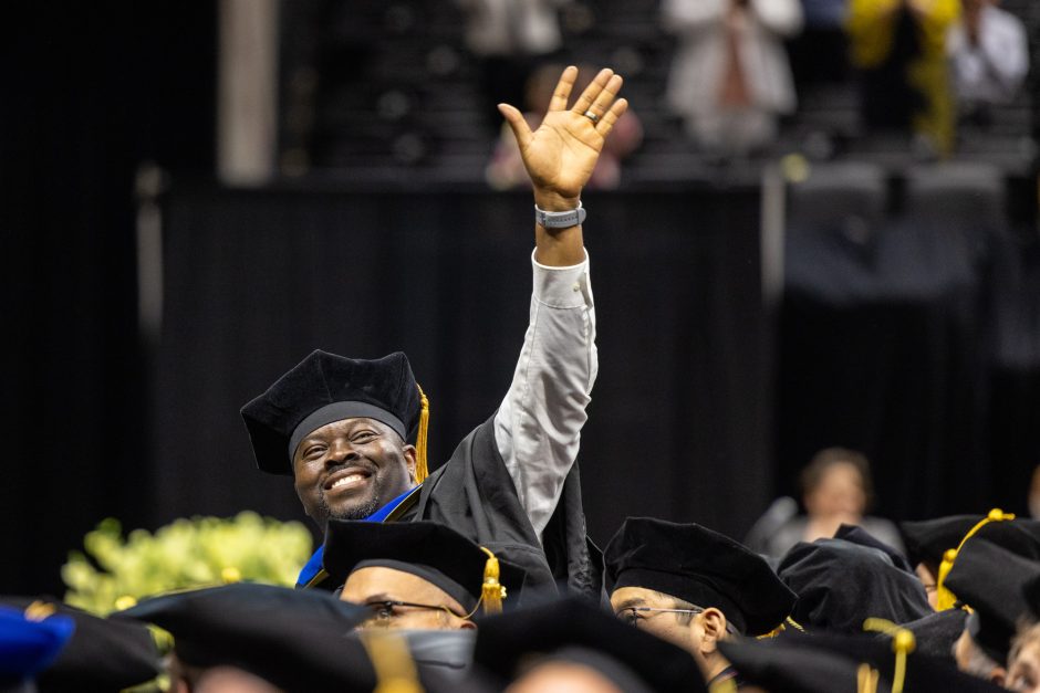 Graduate raises arm in crowd