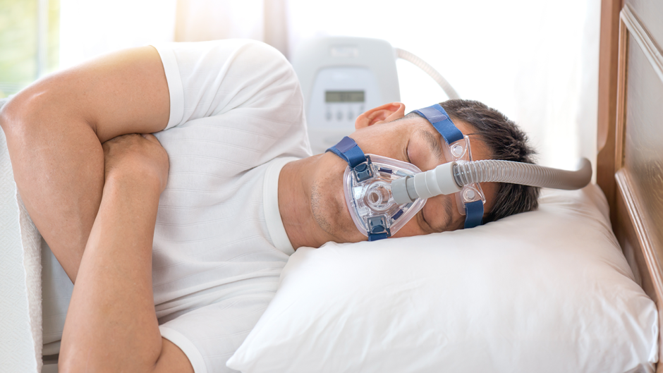 A man sleeping with a CPAP machine.