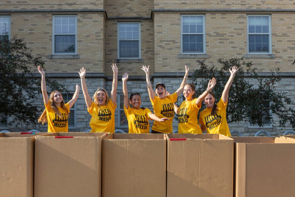 Students raising arms above boxes