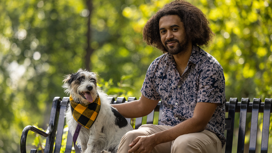 A dog with his owner on a bench in Peace Park.