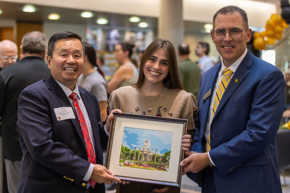 Three people with framed art