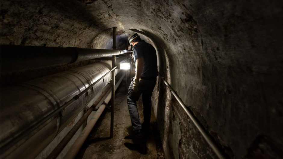 worker in underground steam tunnel