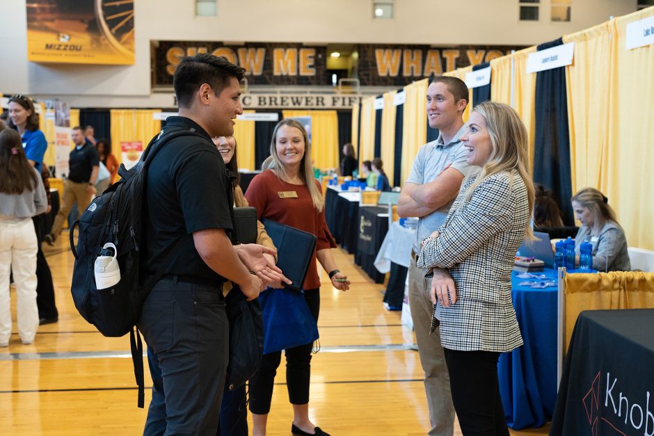 Students and employers smiling at career fair