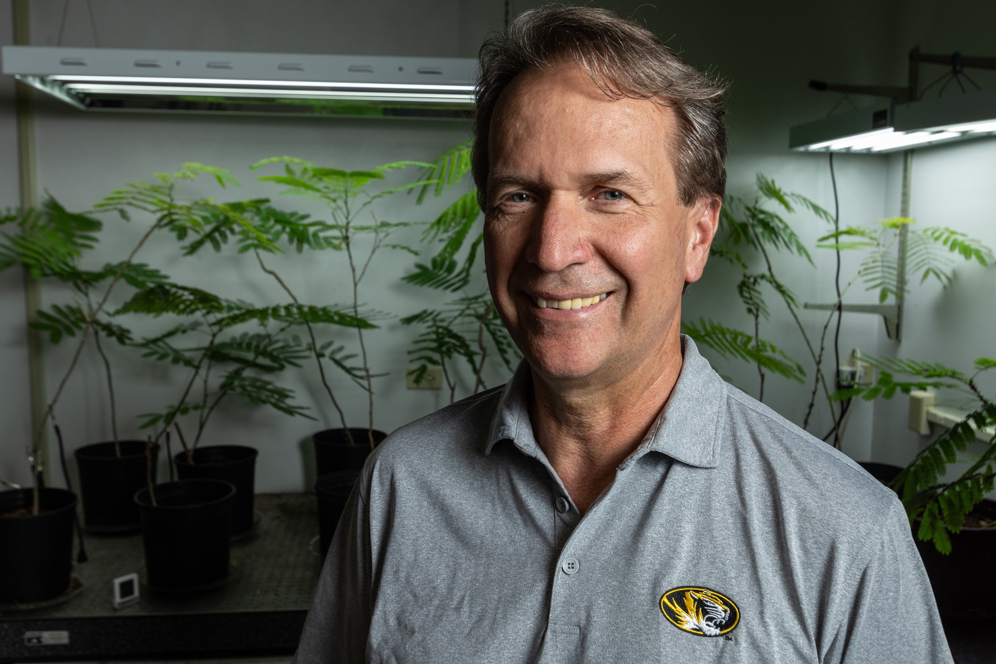 Rex Cocroft standing in front of plants in his lab