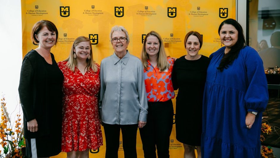 group of people standing in front of a backdrop at an event