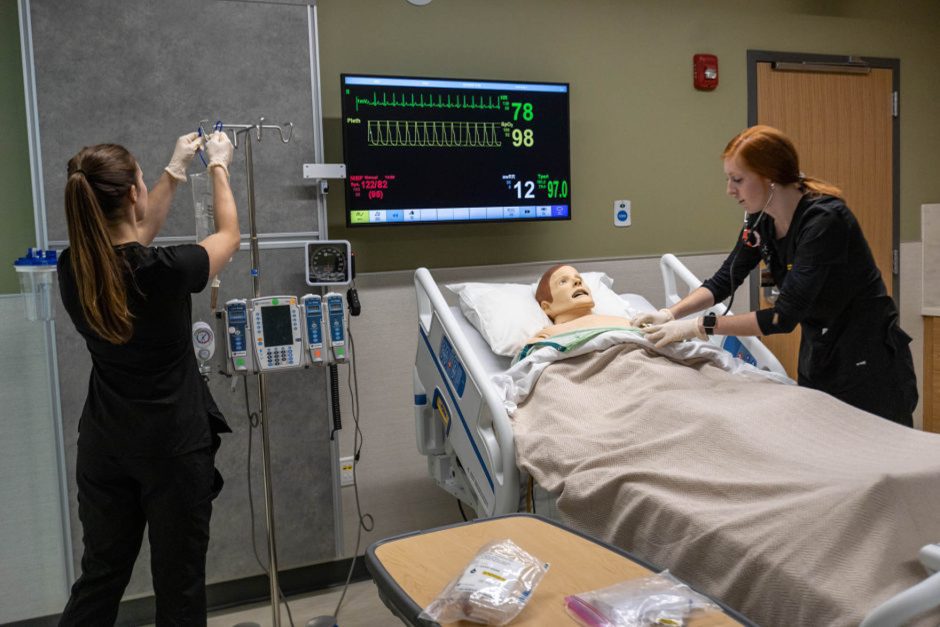 Students work with realistic simulated patient in nursing simulation lab