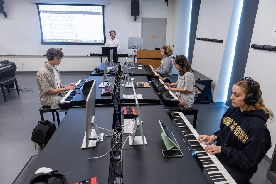 Students in headphones play digital keyboards in the Bastable Family Music Lab