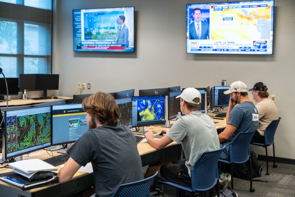 Students analyze weather patterns on screens