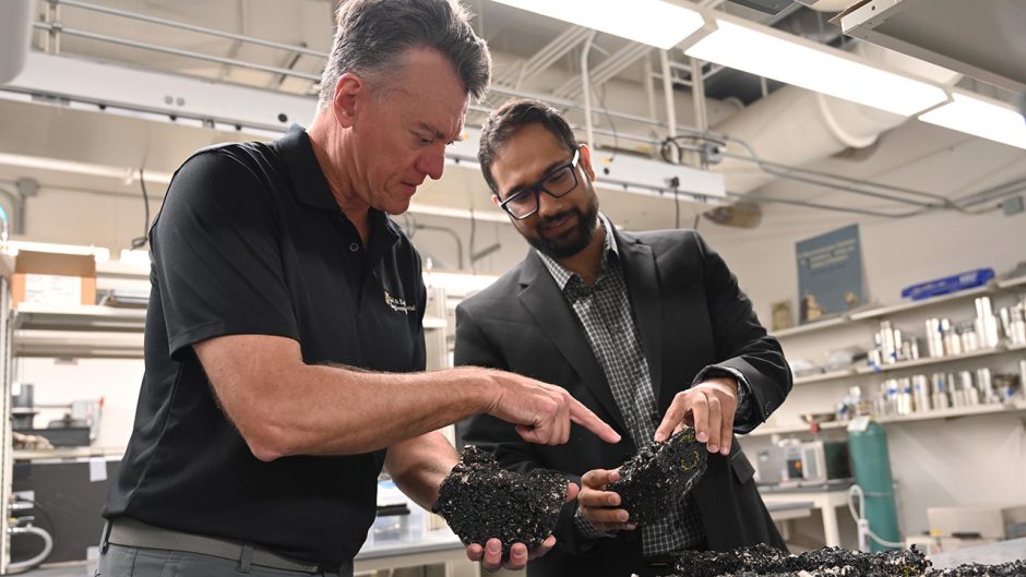 Two men work with rubber-modified asphalt