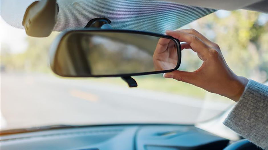 A car mirror being adjusted.