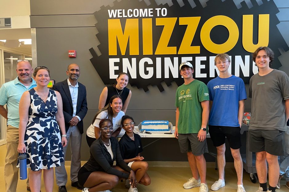 Group of faculty members and students with cake in front of Mizzou Engineering sign