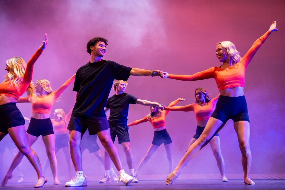 Students dance in front of pink smoke