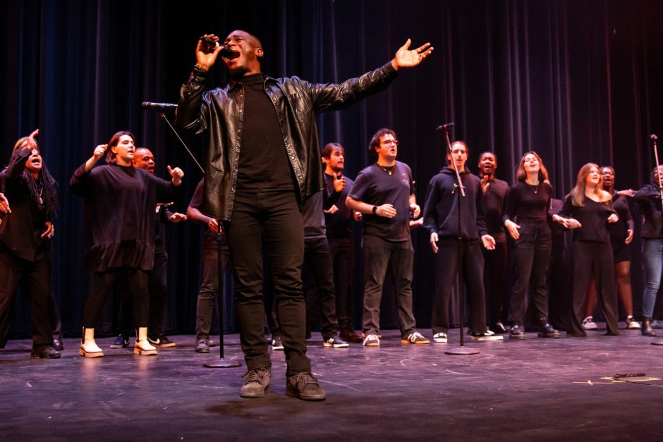 Student sings with microphone and stretched out arm