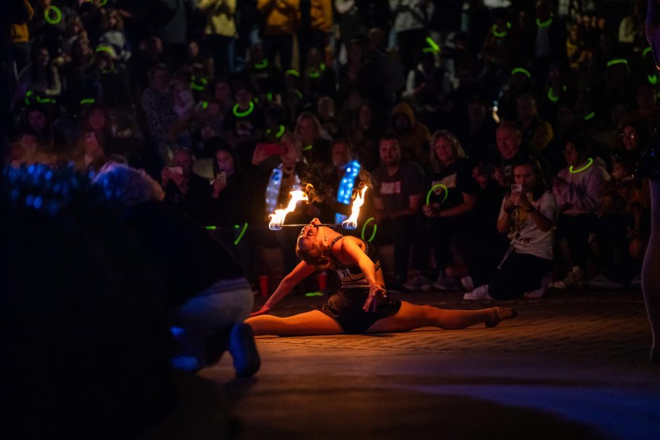 Performer holds rod with fire at both ends in her mouth