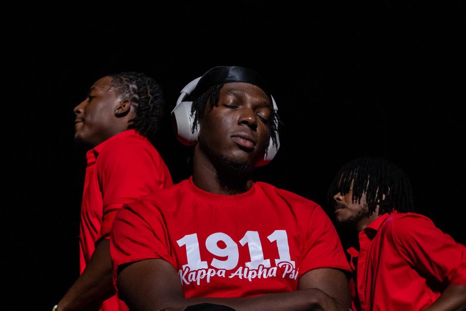 Students in red shirts and earphones at step show