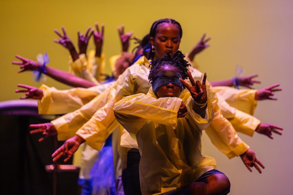 Students raise arms during step show performance