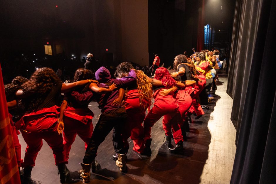 Students with arms interlocked at step show