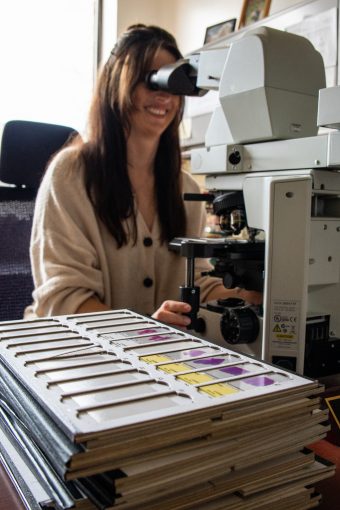 Amanda Smith looking at a sample under a microscope.