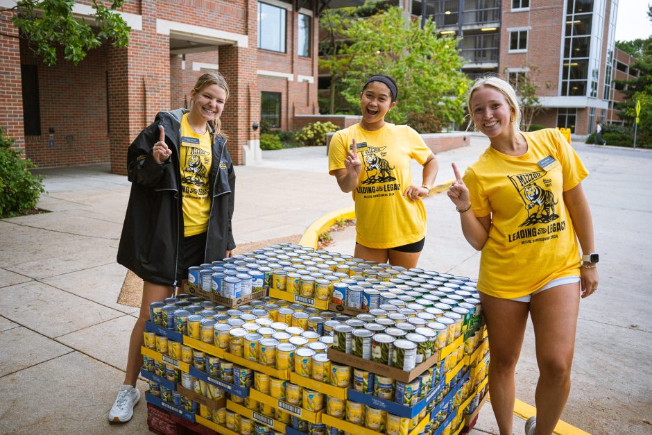 Three students with canned food