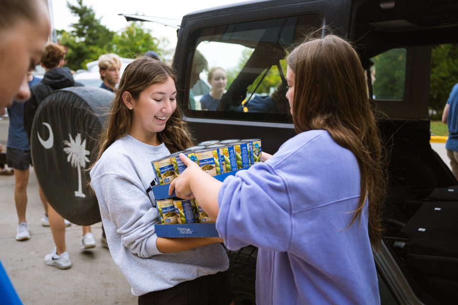 A student hands another student a box of food