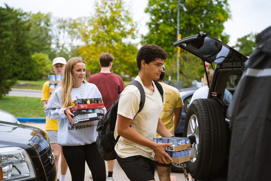 Students load canned food into vehicle