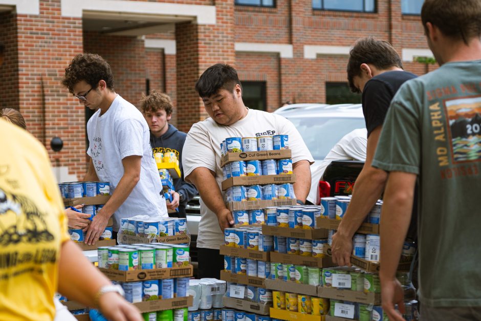 Student picks up box of canned food