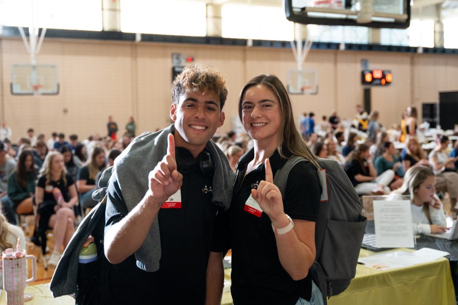 Two students smile at camera