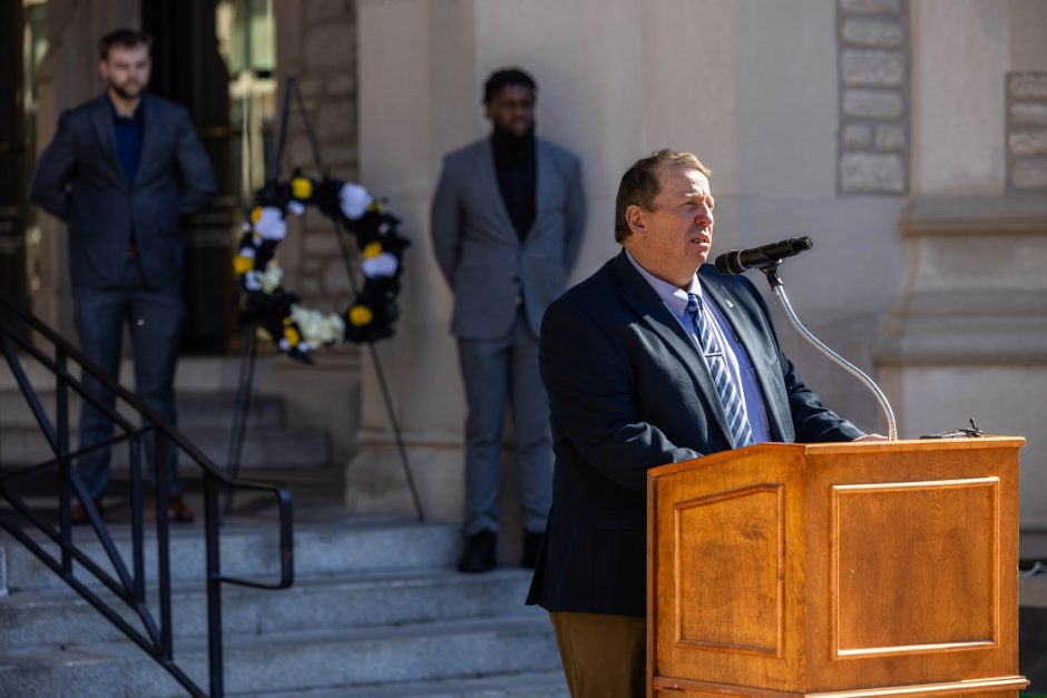 Man at podium speaks during ceremony