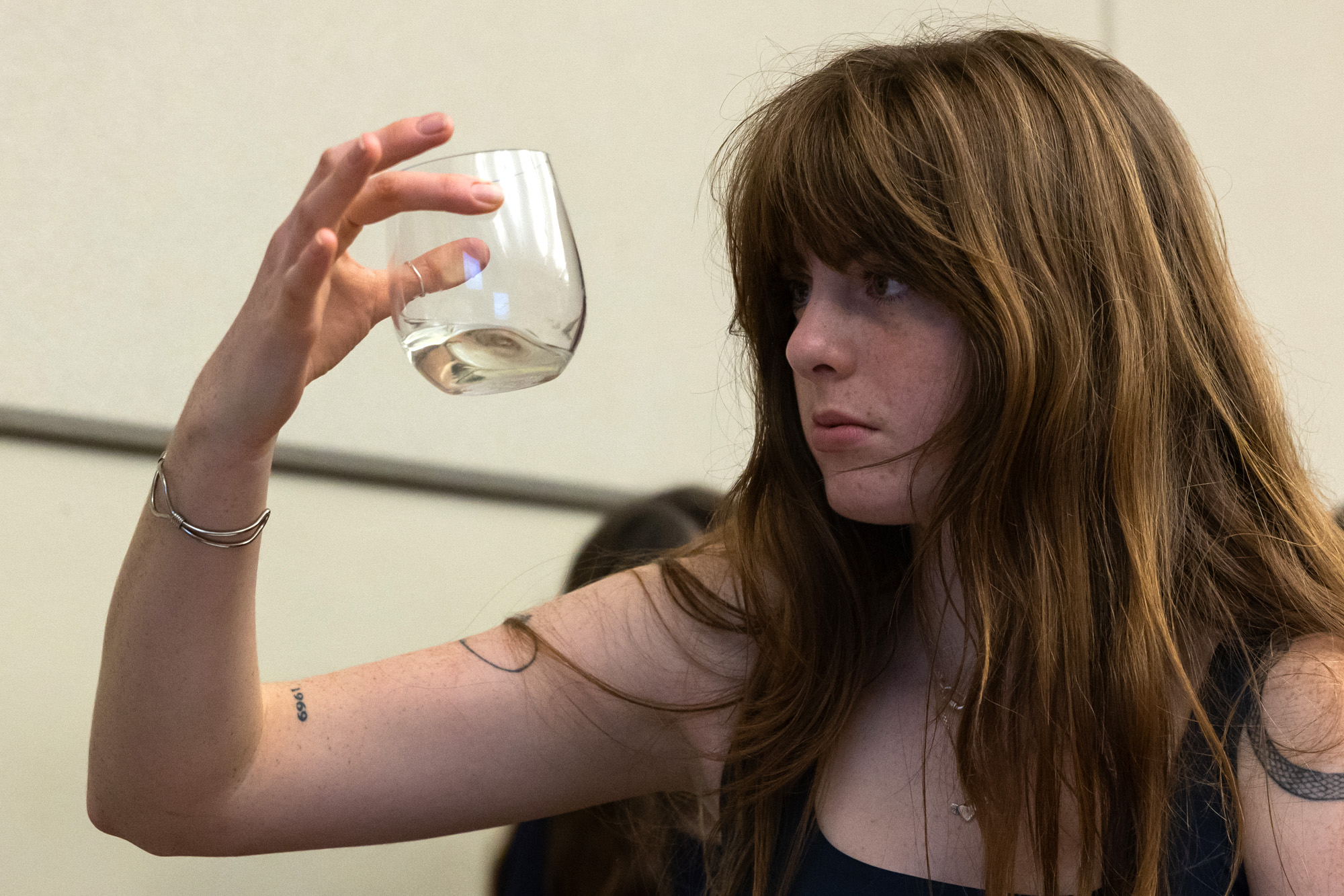 Ella Redford examines a tumbler of white wine