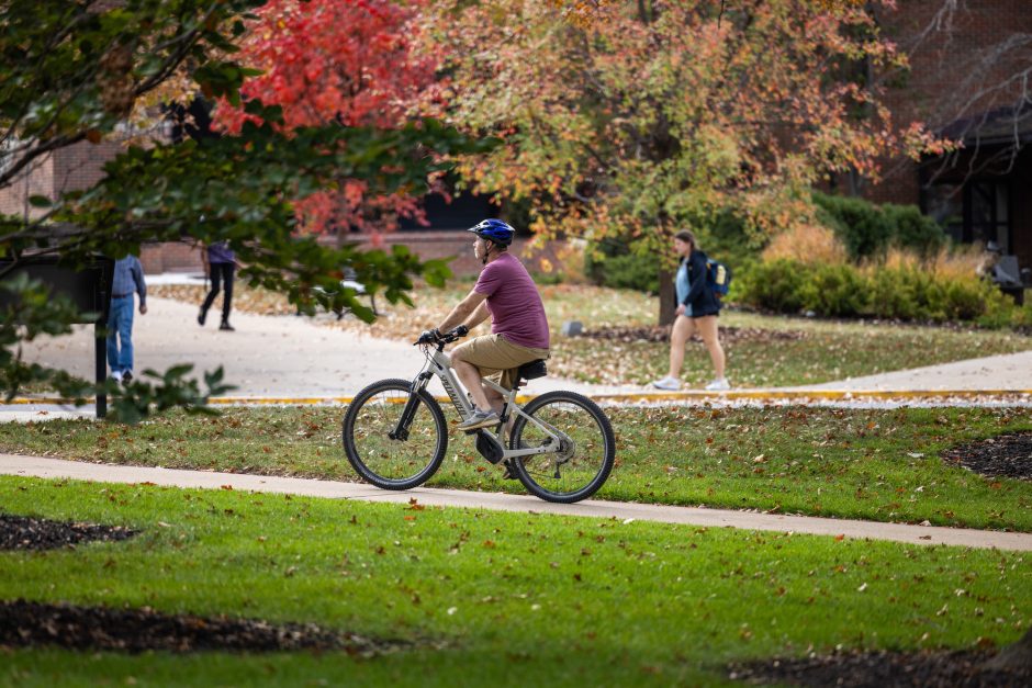 Red and green leaves frame a bicycles on campus