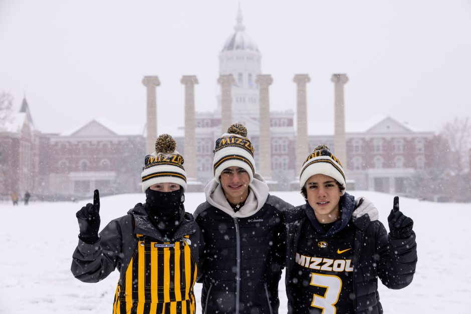 Three people with Mizzou attire in snow