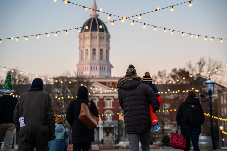 String of white lights above group of people