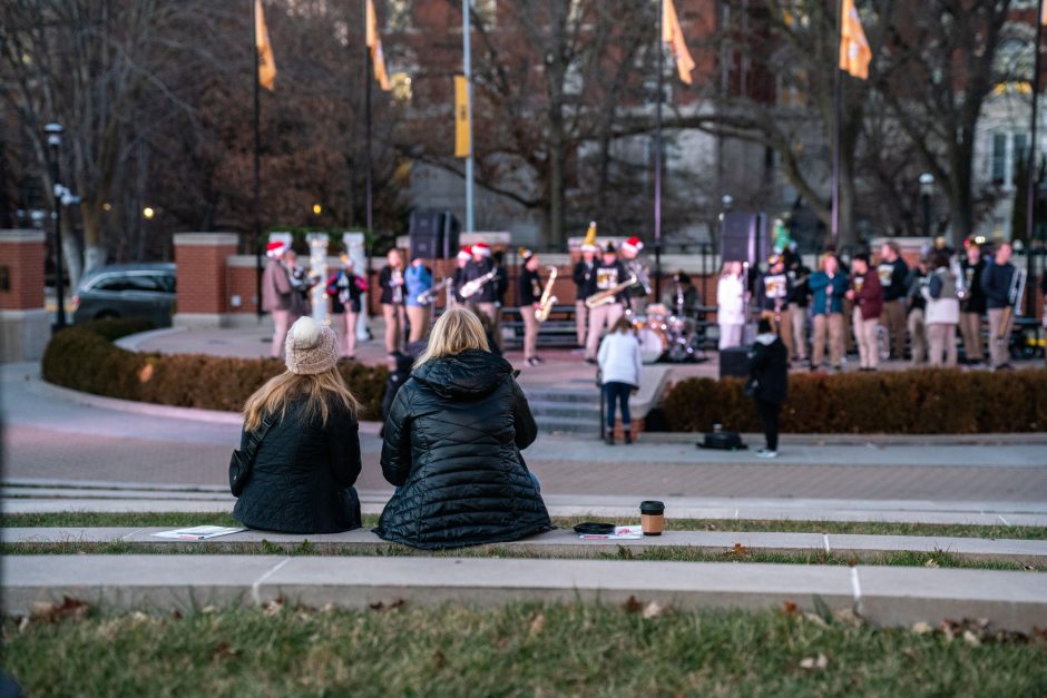 Two people sit watching band