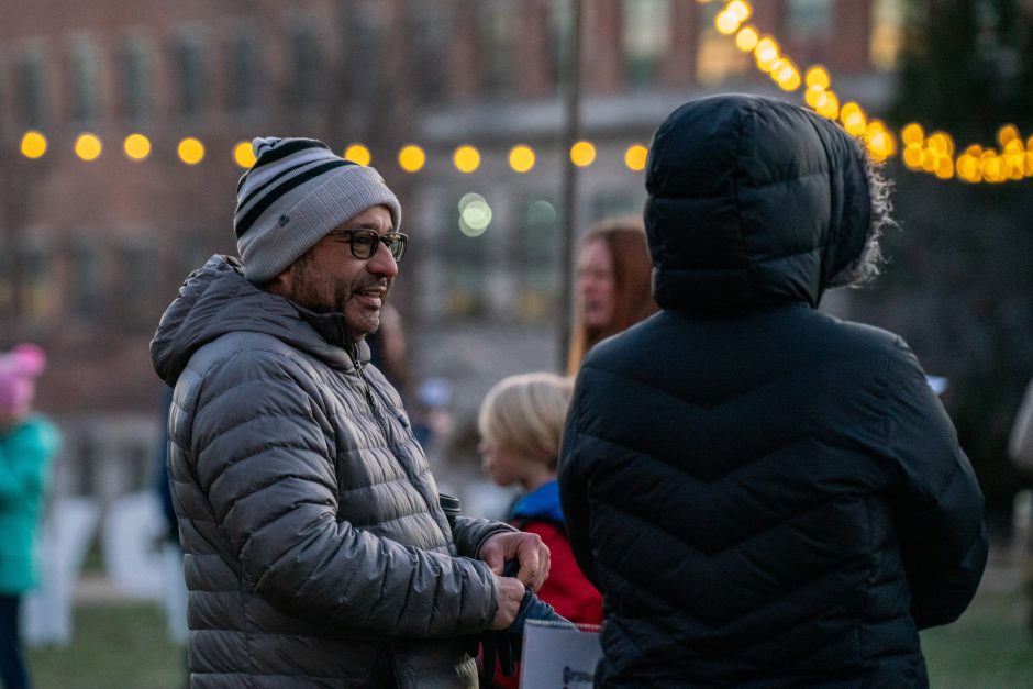 Two people talk with lights around them